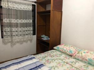a bedroom with a bed and a dresser at Apartamento de 2 quartos com Ar Condicionado na Enseada in Guarujá