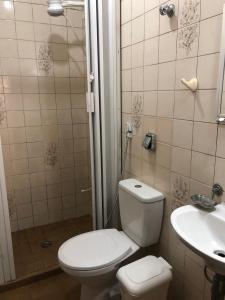 a bathroom with a toilet and a sink at Apartamento de 2 quartos com Ar Condicionado na Enseada in Guarujá