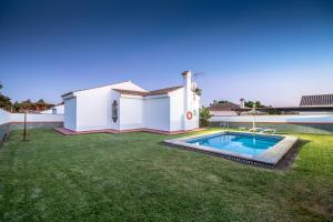 a backyard with a swimming pool and a house at Chalet Pedro III in Conil de la Frontera