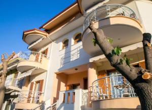ein Gebäude mit Balkonen und einem Baum davor in der Unterkunft Vier Luxury House in Serres