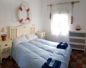 a bedroom with a bed with two towels on it at Auténtica vivienda de pescadores en primerísima línea de playa in Villajoyosa