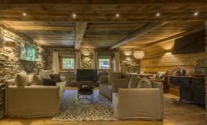 a living room filled with furniture and a stone wall at Hotellerie De Mascognaz in Champoluc