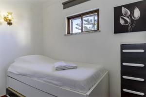 een witte kamer met een bed en een raam bij FLH Gaivotas Cozy House in Porches