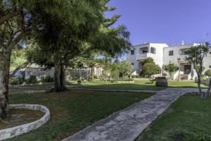 een tuin met bomen en een gebouw op de achtergrond bij FLH Gaivotas Cozy House in Porches