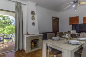 een eetkamer met een tafel en een open haard bij FLH Gaivotas Cozy House in Porches