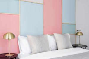 een slaapkamer met een bed met witte kussens en 2 lampen bij Color Apartments by Olala Homes in Madrid
