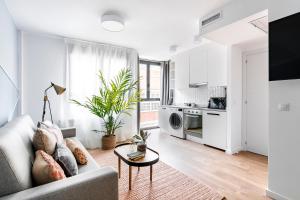 een witte woonkamer met een bank en een tafel bij Color Apartments by Olala Homes in Madrid