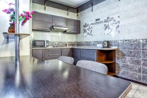 Una gran cocina con una mesa y sillas de madera. en 32 Апартаменты в центре города - выбор для туриста и деловых поездок, en Almaty