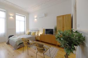 a bedroom with a bed and a tv in a room at FLH Living Oporto Lofts in Porto
