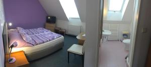 una camera con letto viola e un bagno di Penzion Jordán a Lednice