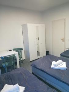 a room with two beds and a table and a mirror at Kunstgasse 11 Wohnung 8 in Altenburg