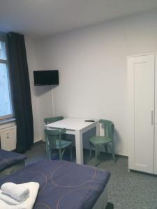 a room with a table and chairs and a tv at Kunstgasse 11 Wohnung 8 in Altenburg