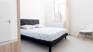 een slaapkamer met een bed met een zwart hoofdeinde bij Séjour chez le Marin in Le Havre