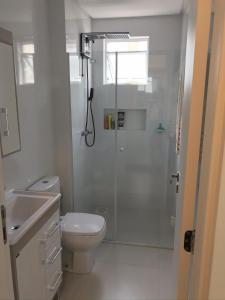 biała łazienka z prysznicem i toaletą w obiekcie Apartamento 2 dormitórios a 350 metros do mar na Meia Praia - Itapema-sc w mieście Itapema