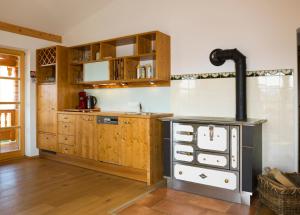 a kitchen with wooden cabinets and a stove at GolfAmGutshof18 in Bad Griesbach