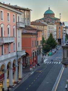 a city street with buildings and a dome in the distance at Liluna in Bologna