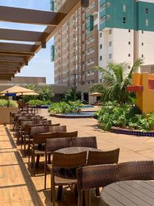 eine Außenterrasse mit Tischen und Stühlen und Gebäuden in der Unterkunft Apartamento no Olímpia Park in Olímpia