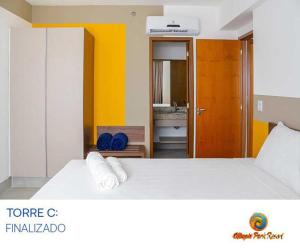 ein Schlafzimmer mit einem weißen Bett und einer gelben Wand in der Unterkunft Apartamento no Olímpia Park in Olímpia + 19 Fotos