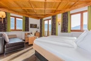 una camera da letto con un letto, una sedia e finestre di Hettlerhof a Maishofen