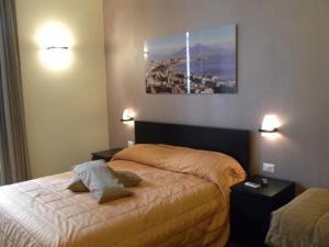 1 dormitorio con 1 cama y una foto en la pared en B&B Il Campanile, en Nápoles