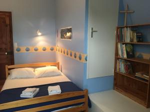 een slaapkamer met een bed en een boekenplank bij villa Canthar in Saint-Pair-sur-Mer