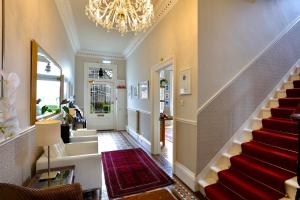 a hallway with stairs and a chandelier at Sheridan Guest House in Edinburgh