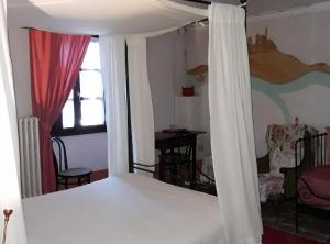 a bedroom with a bed with a white canopy at Agriturismo Olivazzi in Quattordio