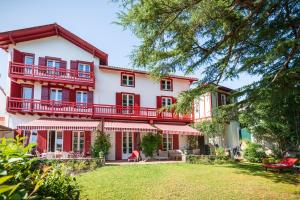 a large red and white house with a yard at Aita Baita in Ciboure