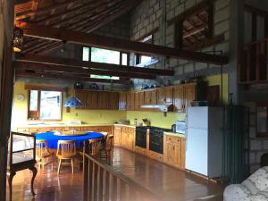 a kitchen with a blue table and a refrigerator at Cabañas 5 Pinos in Pinal de Amoles