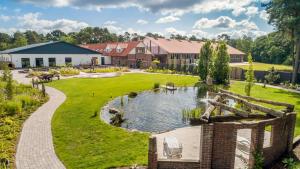 a garden with a pond and a house at Haus am Parc in Meppen