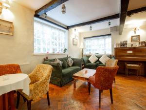 a living room with a couch and chairs and a piano at Wincham Hall Hotel in Northwich