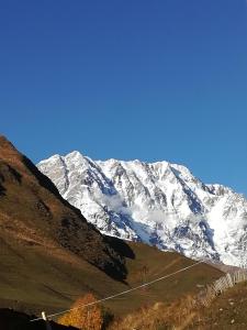 a snow covered mountain with a road in front of it at Bori's Guesthouse in Ushguli