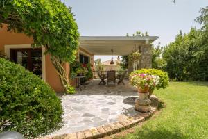 een tuin met een patio met een tafel en bloemen bij Villa Anna in Ágios Ioánnis