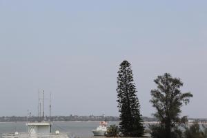 two trees and a boat in a body of water at Afrin Prestige Hotel in Maputo