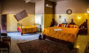 a bedroom with two beds and a clock on the wall at Haven La Chance Desert Hotel in Merzouga