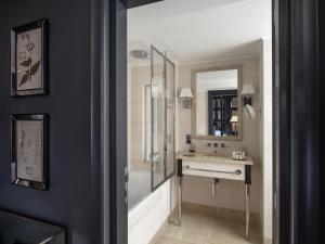 a bathroom with a tub and a sink and a mirror at The Franklin London - Starhotels Collezione in London