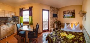 a bedroom with a bed and a table and a kitchen at Apartmany Veverica in Liptovský Mikuláš