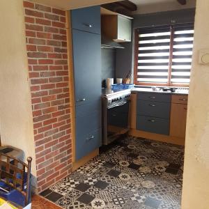 a kitchen with blue cabinets and a tile floor at Maison-Gite métropole Nancy in Vandoeuvre-lès-Nancy