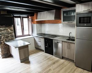 a kitchen with stainless steel appliances and a window at Casa Nastasia in A Pontenova