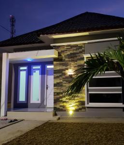uma pequena casa com uma porta azul à noite em Brand new vacation house- Private gated community em Banda Aceh