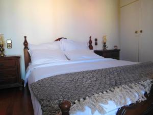 - une chambre dotée d'un grand lit avec des draps et des oreillers blancs dans l'établissement Kavouri beach house just 6 minutes walk to Kavouri beach, à Athènes