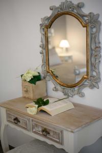 a mirror on a dresser with a book on it at Vintage Village House in Gastouri