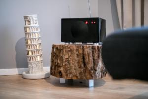 a tv on top of a tree stump with a table with a television at Spacious and sunny apartment in Birstonas center in Birštonas