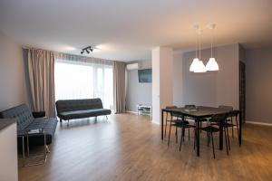 a living room with a table and a couch at Spacious and sunny apartment in Birstonas center in Birštonas