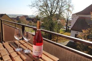 a bottle of wine sitting on a table with two wine glasses at Penzion jaký svět neviděl in Šakvice