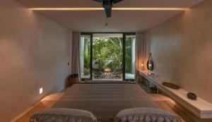 a bedroom with a large bed and a large window at Casa Agape Hotel Tulum & Vegan Restaurant with Beach Club Access in Tulum