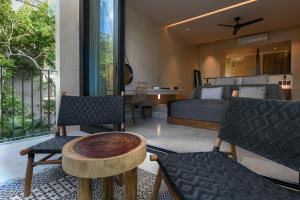 een slaapkamer met een bed en een tafel en stoelen bij Casa Agape Hotel Tulum & Vegan Restaurant with Beach Club Access in Tulum