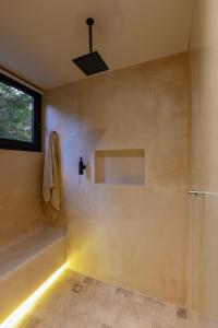 ein Badezimmer mit Dusche und Fenster in der Unterkunft Casa Agape Boutique Hotel Rooftop Pool & Beach club access in Tulum