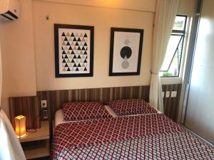 a bedroom with a bed and two pictures on the wall at Beach Place Resort Residence in Aquiraz