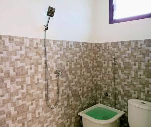 a bathroom with a toilet and a shower in it at Brand new vacation house- Private gated community in Banda Aceh